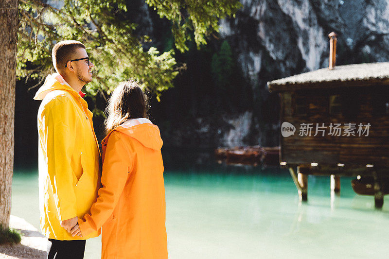 在Dolomites阿尔卑斯山脉的阳光明媚的夏天日出期间，女人和男人呆在Lago Di braes附近